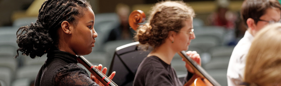 women playing cello in orchestra