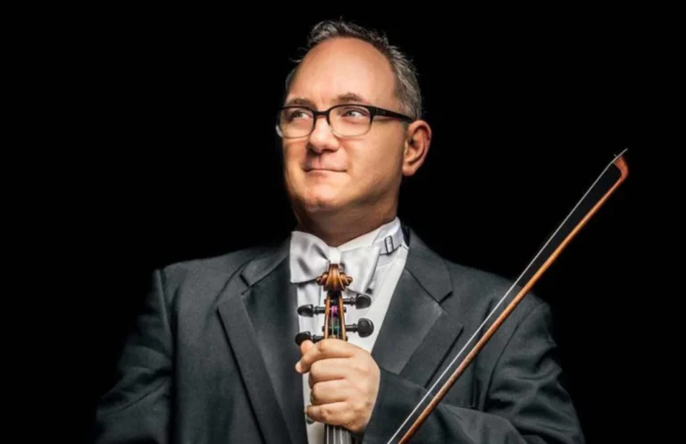 Concertmaster Andrew Irvin of the Arkansas Symphony Orchestra holding his violin and bow